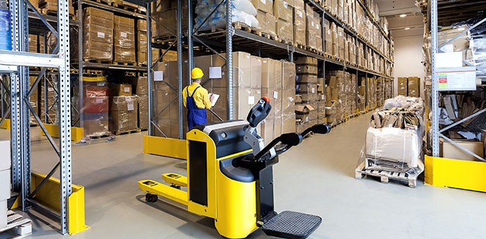 Commercial Combined Insurance: A man within a warehouse checking stock next to a forklift. 