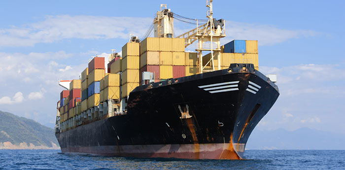 Marine Insurance: A large ship transporting lots of containers across the sea.