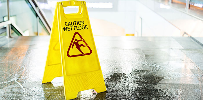 Public Liability Insurance: A yellow caution wet sign floor at the top of stairs. 
