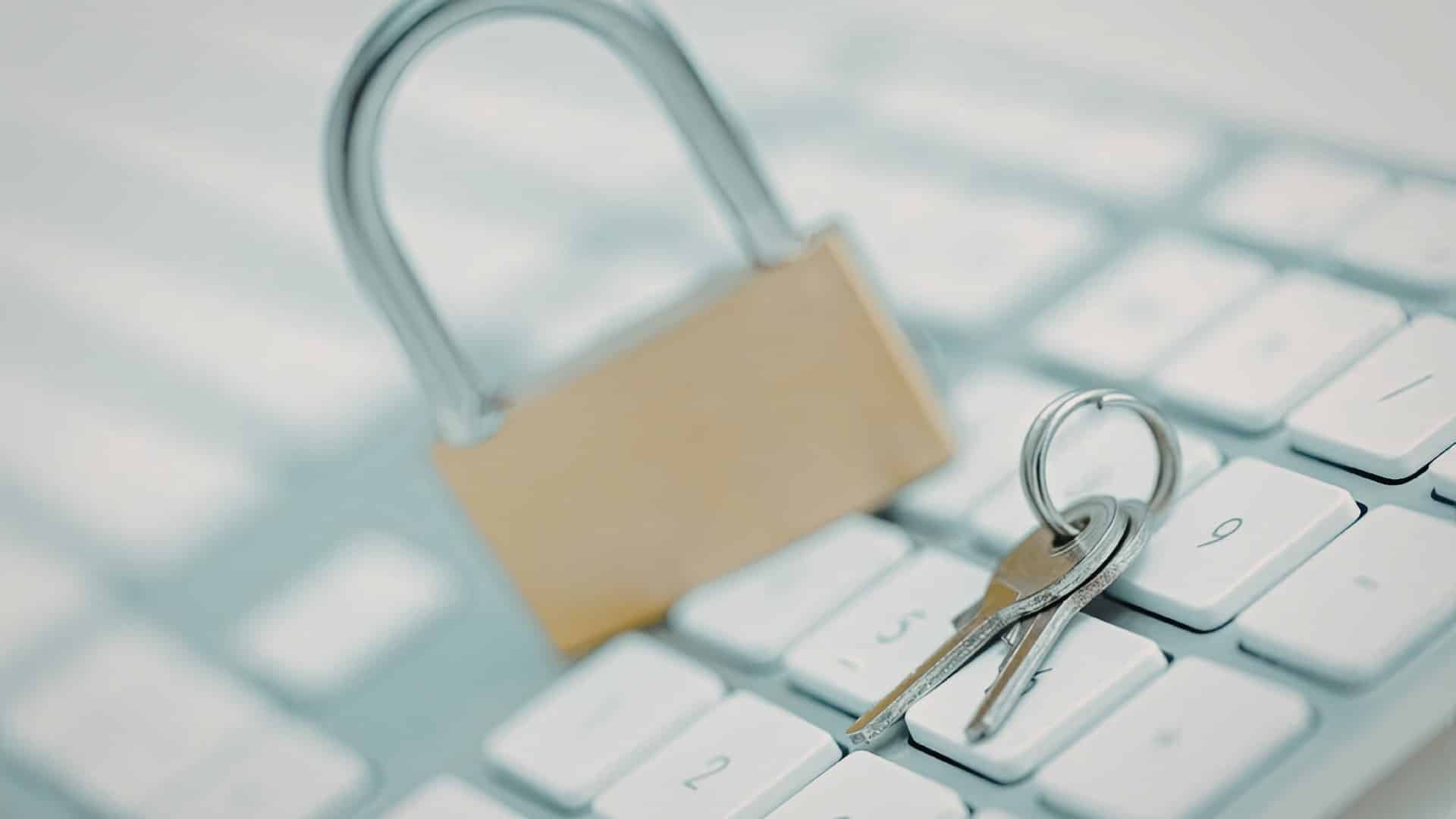 Physical padlock on a laptop keyboard — cyber security fundamentals remain critical as AI-enabled threats accelerate