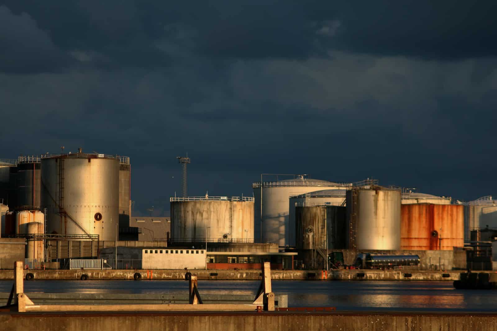 Bulk fuel storage tanks on an industrial site at dusk